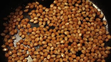 Mısır patlamış mısır, ev yapımı pişirme, hindistan cevizi yağında cızırdıyor siyah tencerenin dibinde.