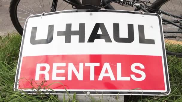 Uhaul 임대료 포장지에 자전거 자전거를 포스트에 기대는 잔디에 직사각형 — 비디오
