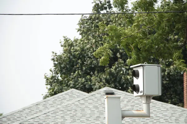 フレームの右下の赤いライト シルバーの写真のカメラは屋根の煙突が付いているポストおよび背景の木から突き出ます — ストック写真