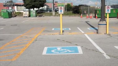 Özürlü simgesinin altında yazılı minibüs engelli park alanı, arka planda geçen trafik araçları