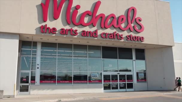 マイケルズ 芸術と工芸品は前を歩いている車を運転する顧客および車の入口を貯えます — ストック動画
