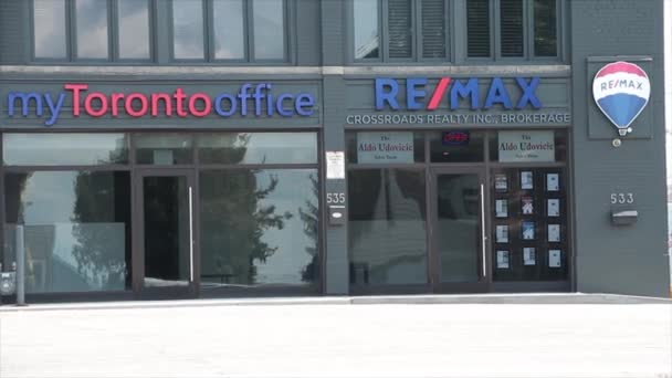 我的Toronto办公室重新设计了十字路口房地产经纪黑楼店面入口前面有小停车场 前面有汽车车流 — 图库视频影像