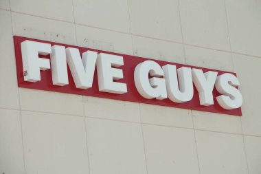 Mağaza duvarına manşet metni yazan beş adam. Kapatın.