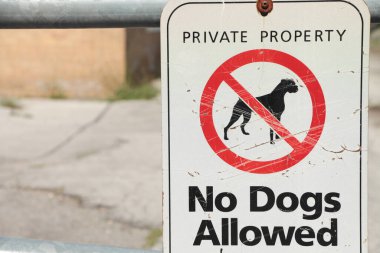Hiçbir köpeğin imzalamasına izin verilmeyen özel mülk. Üstü çizilmiş bir köpek resmi. Beyaz, siyah, kırmızı, bulanık arka plan.