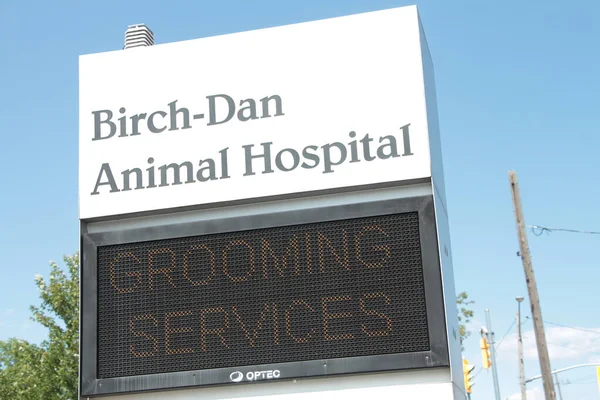 stock image animal hospital front sign with electronic electric digital sign beneath that says grooming services