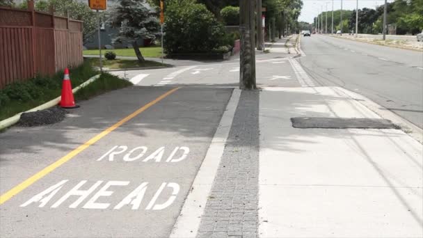 自転車の歩行者道に書かれた道は 黄色い線とパイロン 遠くから来る車の交通機関のセメントの舗装セメントの隣に — ストック動画