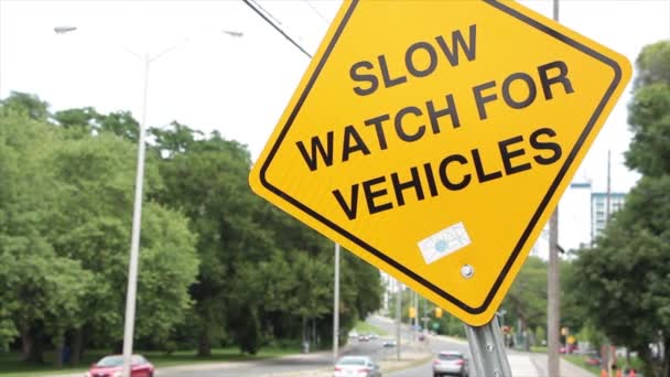 車のための遅い腕時計 黄色いダイヤモンドは道の歩道の隣の印を曲げましたり 車の交通機関が渡る近くに — ストック動画