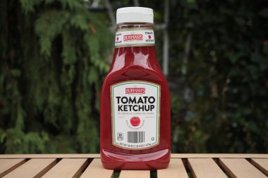 Burman 'lar mükemmel bitirici domates ketçapı suni tatlar ya da renkli kaplar yok açık havada açık kahverengi masada yeşil arkası olan, kapatın.