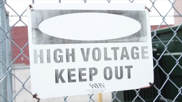 Yüksek Voltaj Dikdörtgen Beyaz Siyah Tabelasını Gümüş Elmas Çitlerin Üzerinde — Stok video