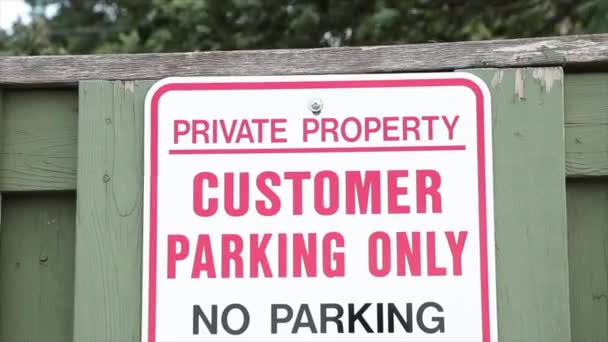 プライベートプロパティの顧客駐車場 緑の木製のピケットフェンスの駐車場は 背後に吹く木 白い赤い黒 — ストック動画