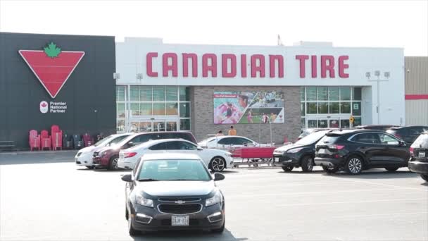 大的加拿大轮胎零售店 前面有停车场 车流经过 一个停车场 顾客走着 拐角处挨了一枪 — 图库视频影像