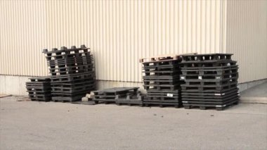 Siyah plastik patinaj paletleri satışta yan yana ve fiyat etiketi bina duvarının köşesinde dış cephede çimentoda.