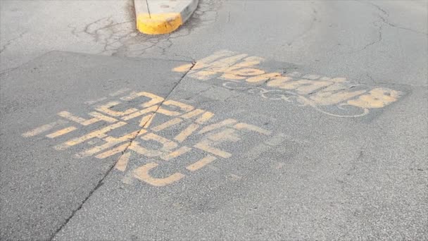 ウェンディーズは 島の隣のドライブスルーエントランスでロゴで黄色の舗装に書かれたテキストキャプションをドライブ — ストック動画
