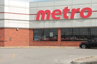 Metro bakkal zinciri serisi önde, logosu büyük olan yakın çekim.
