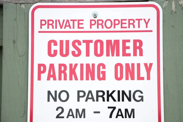 私家物业顾客只可于凌晨2时至7时在绿木栅栏上泊车 为白色 红色及黑色 — 图库照片