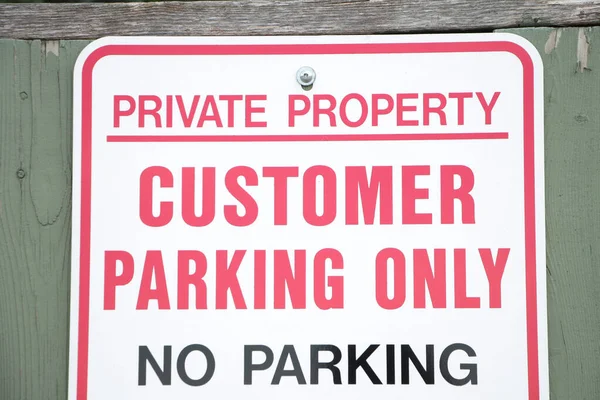 private property customer parking only no parking on green wood picket fence, close up, white red black
