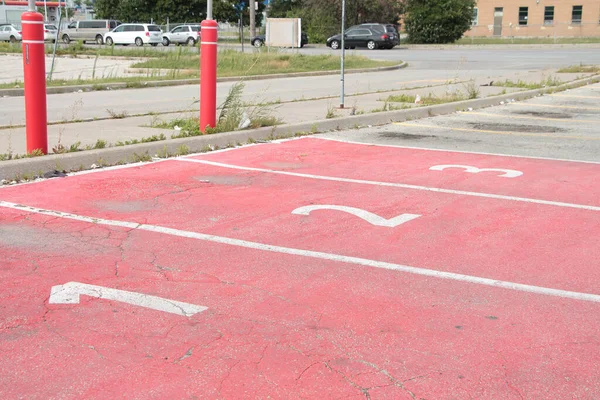 three red parking spots spaces with numbers 1 2 3 in each of them side by side in white for pickup with cars vehicles on road street in background