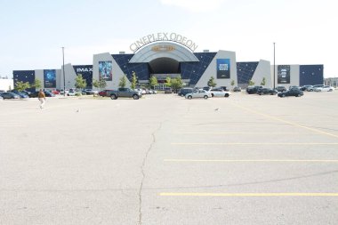 Cineplex Odeon, açık hava tiyatrosunun önünde park yeri ve önünde geniş çerçeveli arabalarla tehdit ediyor.