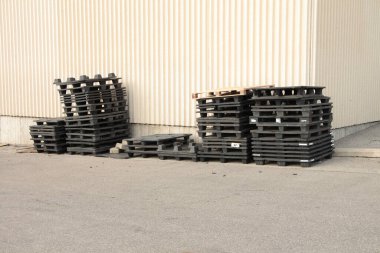 Siyah plastik patinaj paletleri satışta yan yana ve fiyat etiketi bina duvarının köşesinde dış cephede çimentoda.