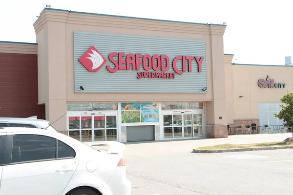 Deniz ürünleri şehri süpermarketi giriş logosu ve kapı otoparkı.