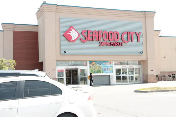 Deniz ürünleri şehri süpermarketinin ön giriş logosu ve müşteri yayası çıkışı olan park yeri.