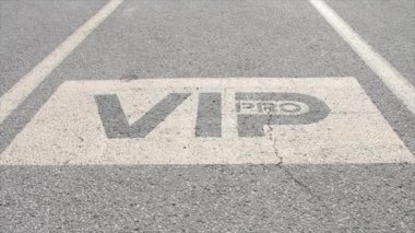 Vip pro yazma manşeti park yeri park yerinde dışarıdaki otoparkta sarı ve siyah güneş ışığı altında.