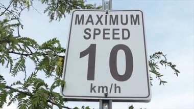 en yüksek hız 10 km ve saat dikdörtgen dikdörtgen dikey beyaz ve siyah işaret metal direği arkasında ağaç