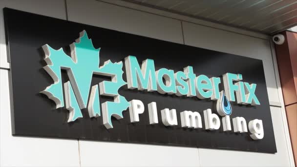 店の前でメープルの葉が付いているマスター修理の配管のMfの長方形の横の印のロゴ 青い白い黒 — ストック動画