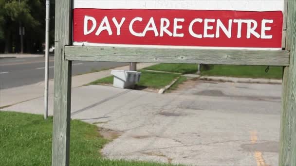 日间护理中心在木制门柱上的标志 外面是木制门框 外面是公路 后面是汽车 车流经过 — 图库视频影像