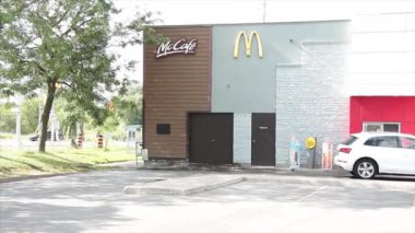 McDonalds Logo ve Mccafe 'nin yazılı olduğu bir restoranın camına doğru sür. Araç aracı pencereye yanaşıyor ve sağa hizalanmak için ileri gidiyor.
