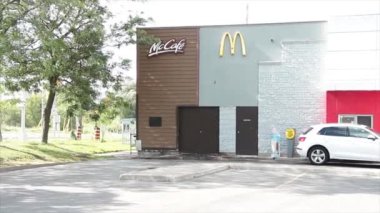 McDonalds Logo ve McKafe 'nin olduğu bir restoran binası. Yaz günü camında araç arabası ve arkasında da başka bir araba vardı.