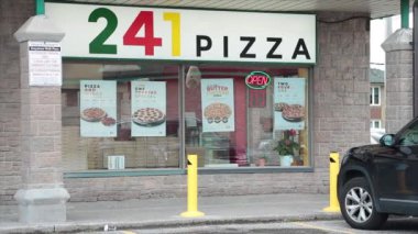 241 pizza dükkanı dükkânı önü pizzacı girişi dikdörtgen işareti logosu ve yol kaldırımı önünde ve penceresinde yanıp sönen neon açık tabelalı animasyon.
