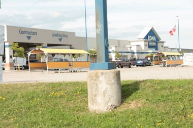 Otopark Bulutları gökyüzü ve Kanada bayrağı ile Rhode Home ve Garden mağaza ön girişi, geniş açı önde ve solda işaret