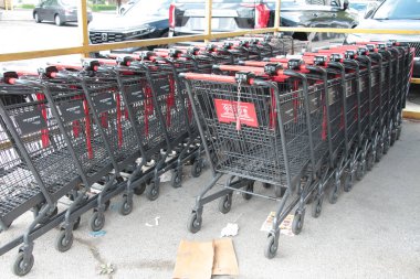 grocery shopping carts buggies parked inside each other inside under corral canopy rain cover outside outdoors exterior, red silver clipart