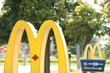 McDonalds yazın girişteki yazılar üzerinde bir diğerinin önünde, soldaki logo çerçevesinde kapanıyor.