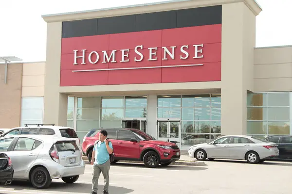 Ev Duyumları Mağazası 'nın girişi önünde park yeri olan ve müşterileri telefondan uzaklaşan biri.