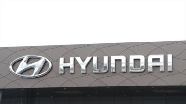 Hyundai gümüş logosu, dışarıdaki gri bayiliğin ön duvarına yazı yazma tabelası. Dış dış dış dış çerçeve.