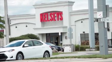 Kelsey 'in restoran girişi, caddenin karşısından ateş edilen müşteriyle birlikte. Araç trafiği ön taraftan geçiyor.