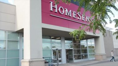 Homesense mağazasının girişi müşterilerle dolu. Dışarı çıkan insanlar buradan geçiyorlar. Açıyla çekiliyorlar.