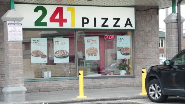 241个比萨饼店店面入口 有矩形标志标识和人行道 前面有行人走过 橱窗里闪烁着霓虹灯开放标志 — 图库视频影像