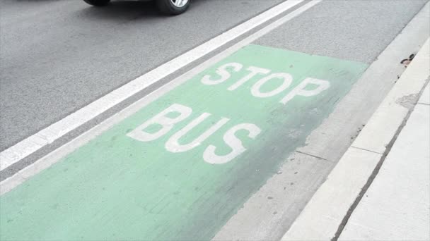 在马路水泥路面自行车道旁边的人行道上 停下来写上公共汽车标题文字 白色背景为绿色 — 图库视频影像