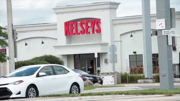 통과하는 교통을 도로의 맞은편에에서 들어가는 고객을 Kelseys 대중음식점 — 비디오
