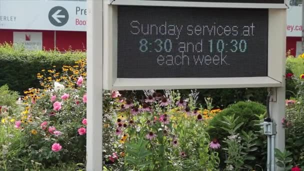 フラワープラントガーデンの電気デジタル電子教会のサインは 夏の日曜日の礼拝の時間静かなコミュニオンエアコン付き教会を祈ると言います — ストック動画
