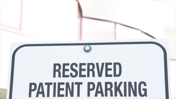 予約患者駐車ライティングキャプションテキストサイン 明るいオフィスビルの背後にあるサイン ホワイトバックグラウンドで黒い書き込み 閉じる — ストック動画