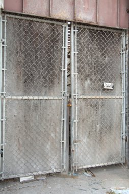 Eski, yıpranmış gümüş bir kapı. Yazın dış tarafta iki gri kapılı. Portre.