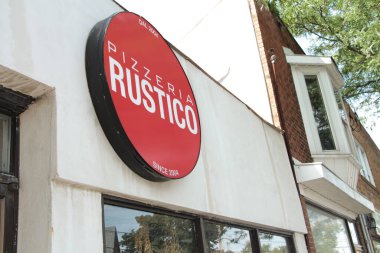 Pizzacı Rustico 2004 'ten beri pencerelerin üstündeki dükkanın önünde kırmızı işaret logosu var.