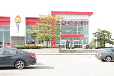 Adonis Akdeniz süpermarket girişi önünde park yeri olan ve müşteri çıkışı yapan kişi logosunu imzalayan market.