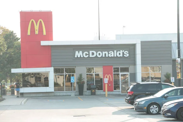 麦当劳餐厅的入口有停车场 前面有车 前面站着电话 — 图库照片