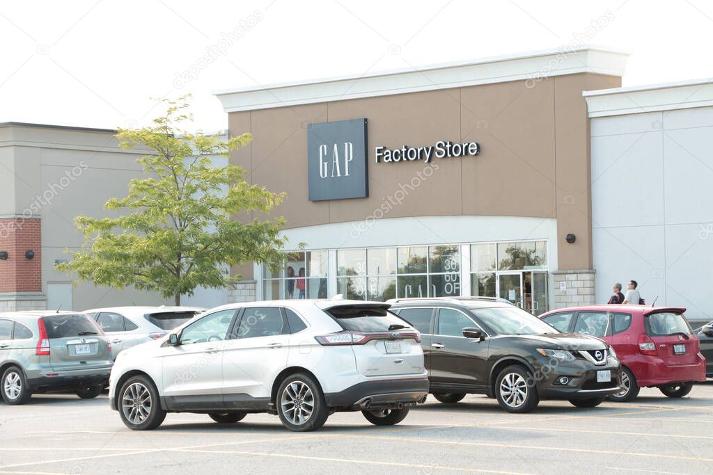 Gap factory store outlet building clothing apparel with parking lot in front with customers walking in front