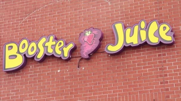 黄紫色和红色的砖墙上的助推器果汁店标志 — 图库视频影像